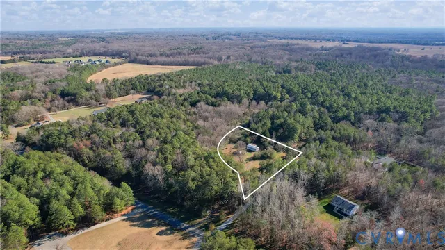 an aerial view of a house with a yard and lake view