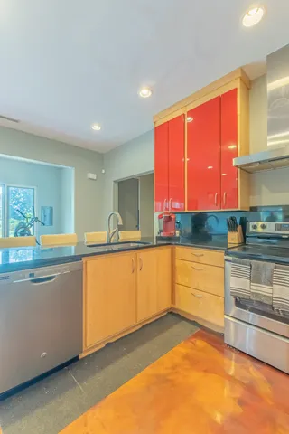 a living room with furniture a large window and stainless steel appliances