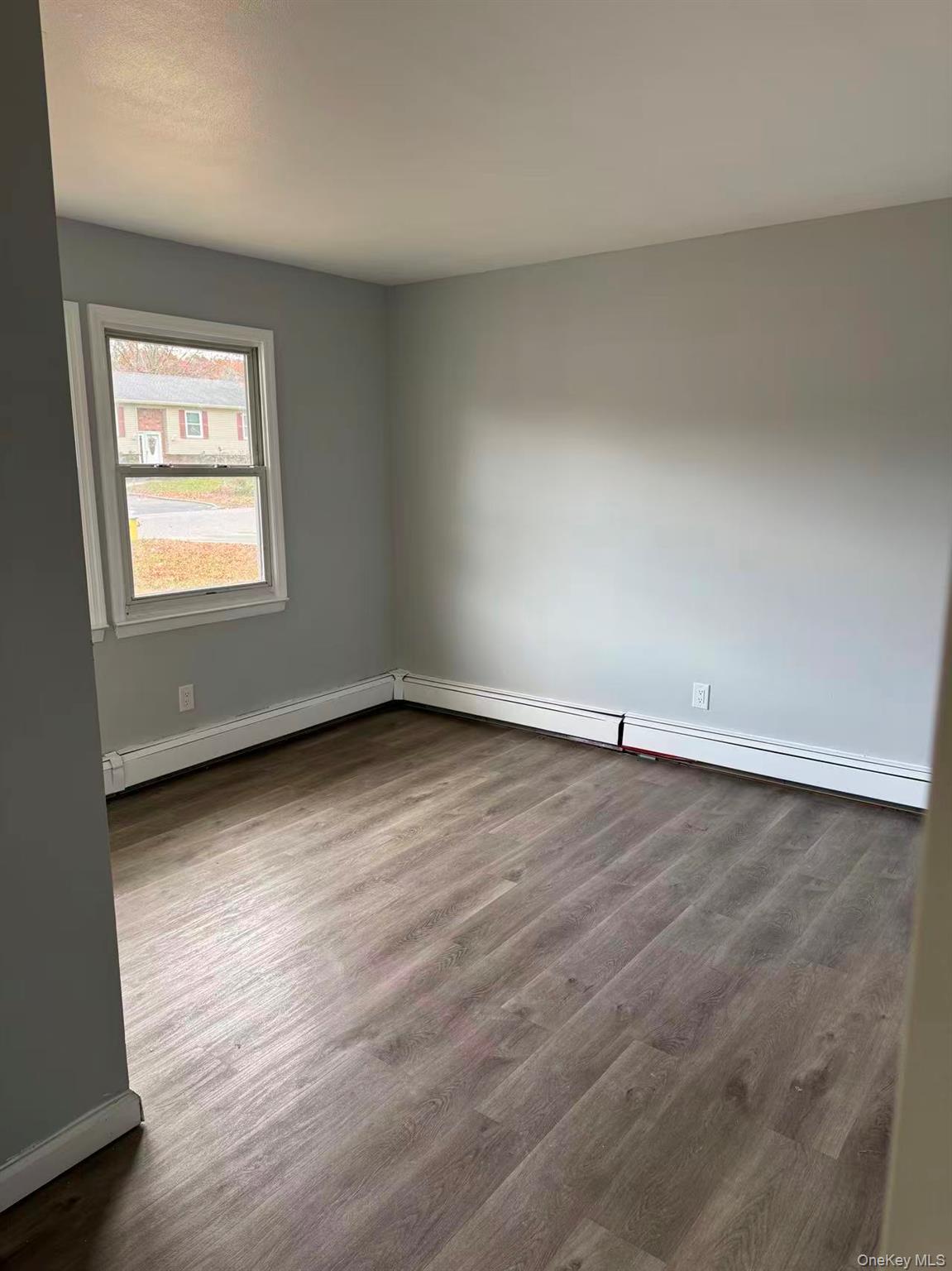 20 Westfield Road Coram, NY 11727 - Photo 13 of 21 an empty room with wooden floor and windows
