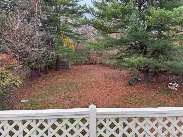 a view of a yard with wooden fence