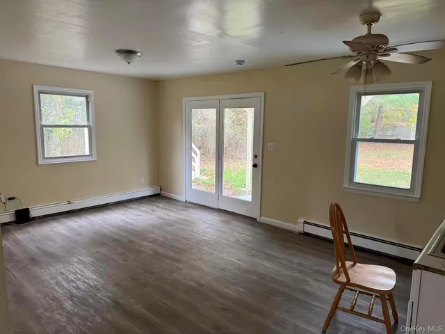 a view of workspace with wooden floor ceiling fan and windows