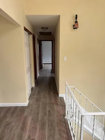 a view of a hallway with wooden floor and stairs