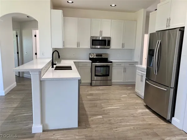 a kitchen with stainless steel appliances a refrigerator stove and sink