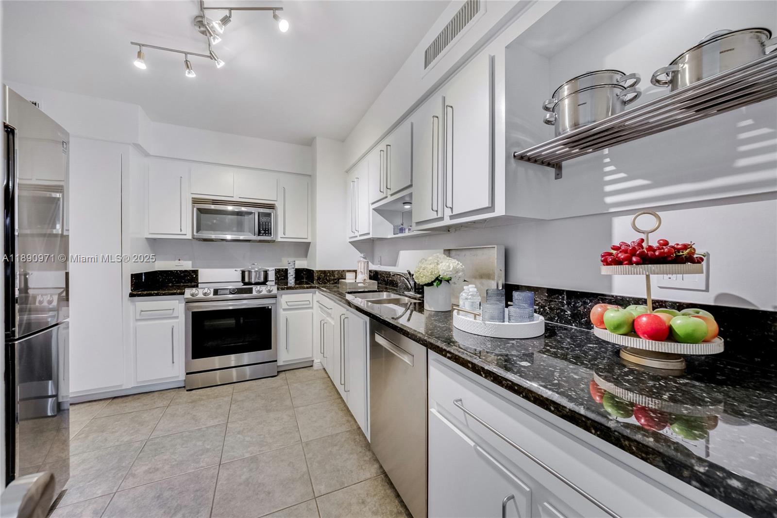9225 Collins Avenue, Unit 501 Surfside, FL 33154 - Photo 6 of 12 a kitchen with kitchen island granite countertop a sink stainless steel appliances and cabinets