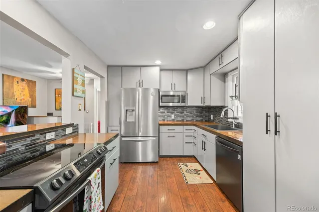 a large kitchen with stainless steel appliances granite countertop a stove and a refrigerator