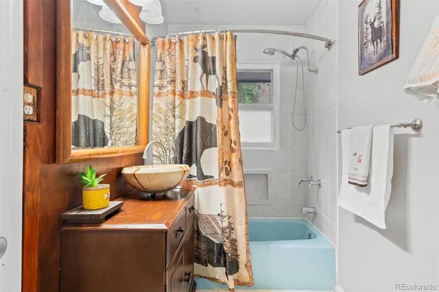 a bathroom with a tub sink and mirror