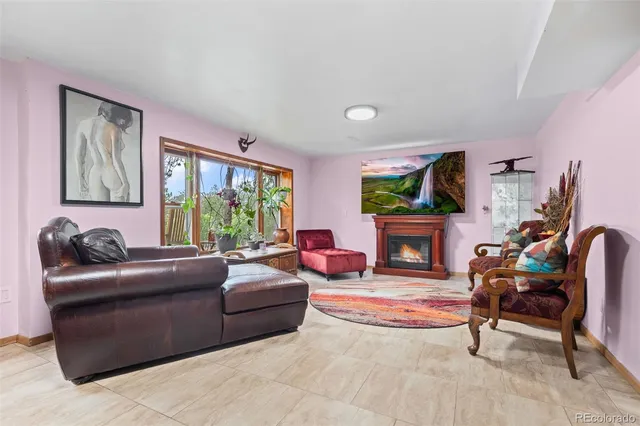 a living room with fireplace furniture and a large window