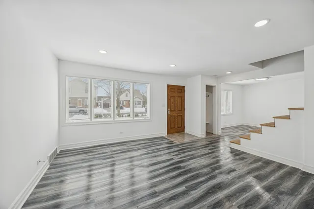 a view of a room with wooden floor and windows
