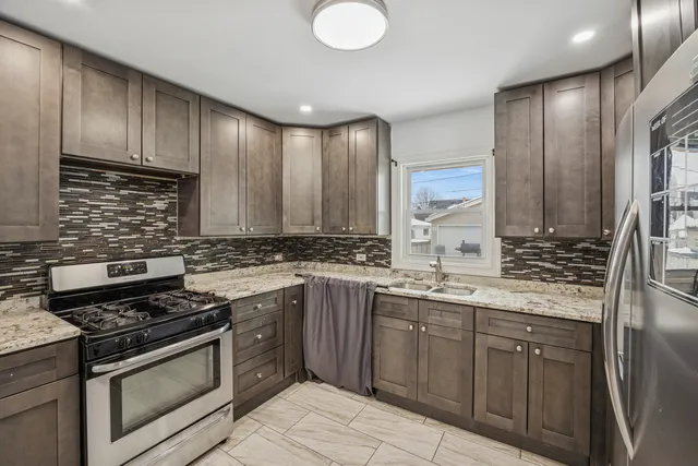 a kitchen with stainless steel appliances a sink stove and cabinets