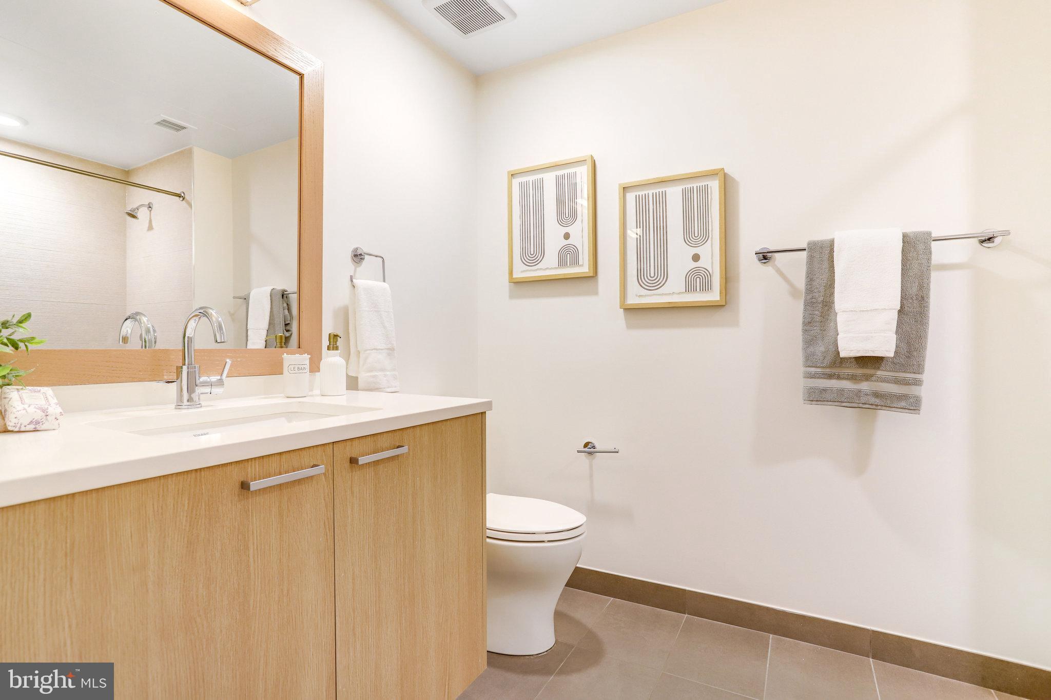 525 Water Street Southwest, Unit 223 Washington, DC 20024 - Photo 16 of 68 a bathroom with a granite countertop sink a toilet and a mirror