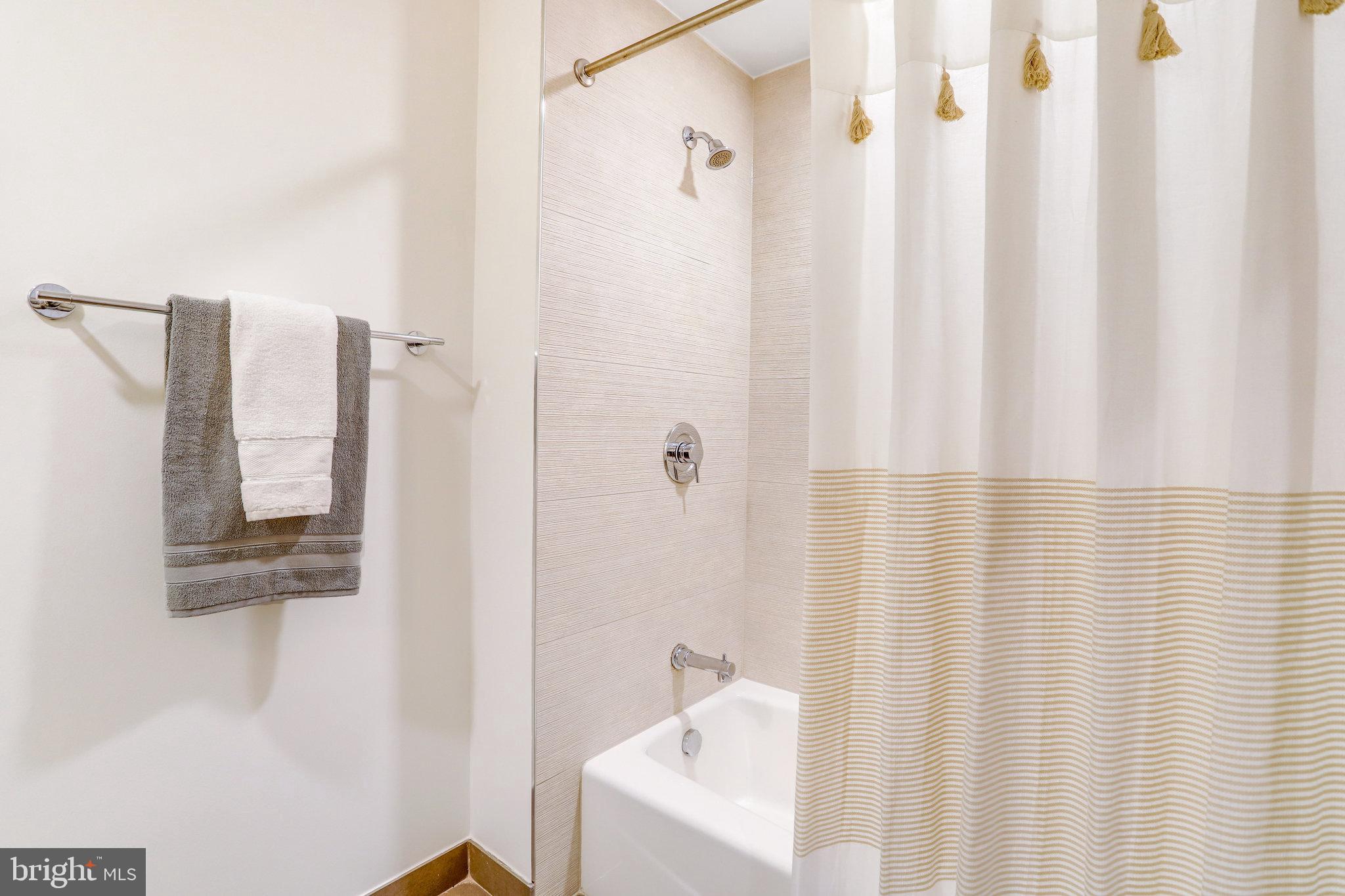 525 Water Street Southwest, Unit 223 Washington, DC 20024 - Photo 17 of 68 a bathroom with a shower curtain and a sink