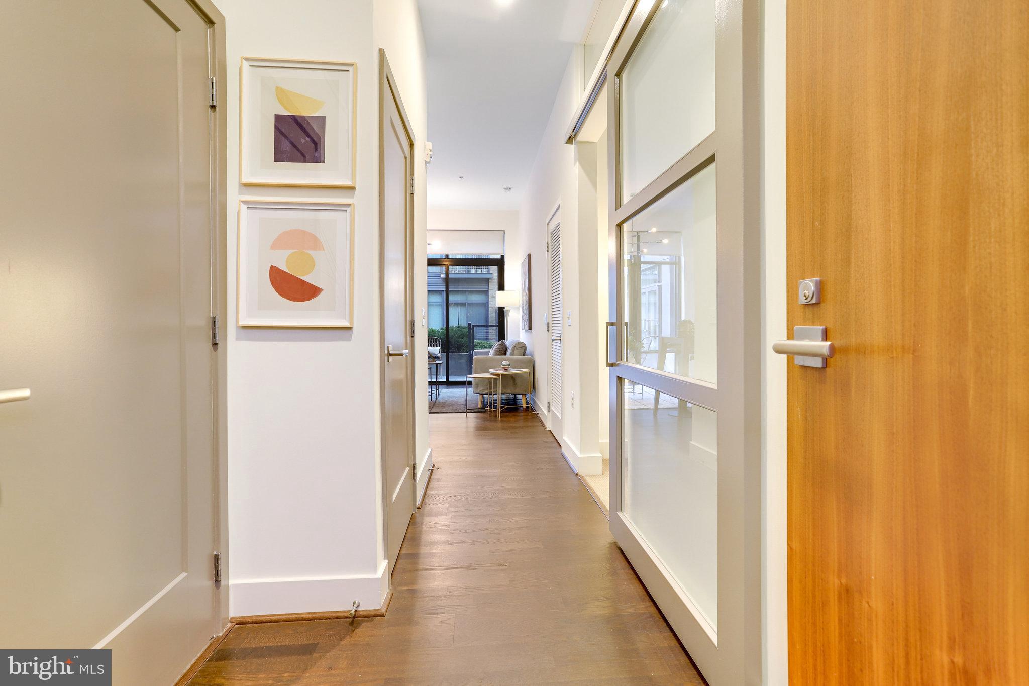 525 Water Street Southwest, Unit 223 Washington, DC 20024 - Photo 3 of 68 a view of a hallway with wooden floor and a bathroom