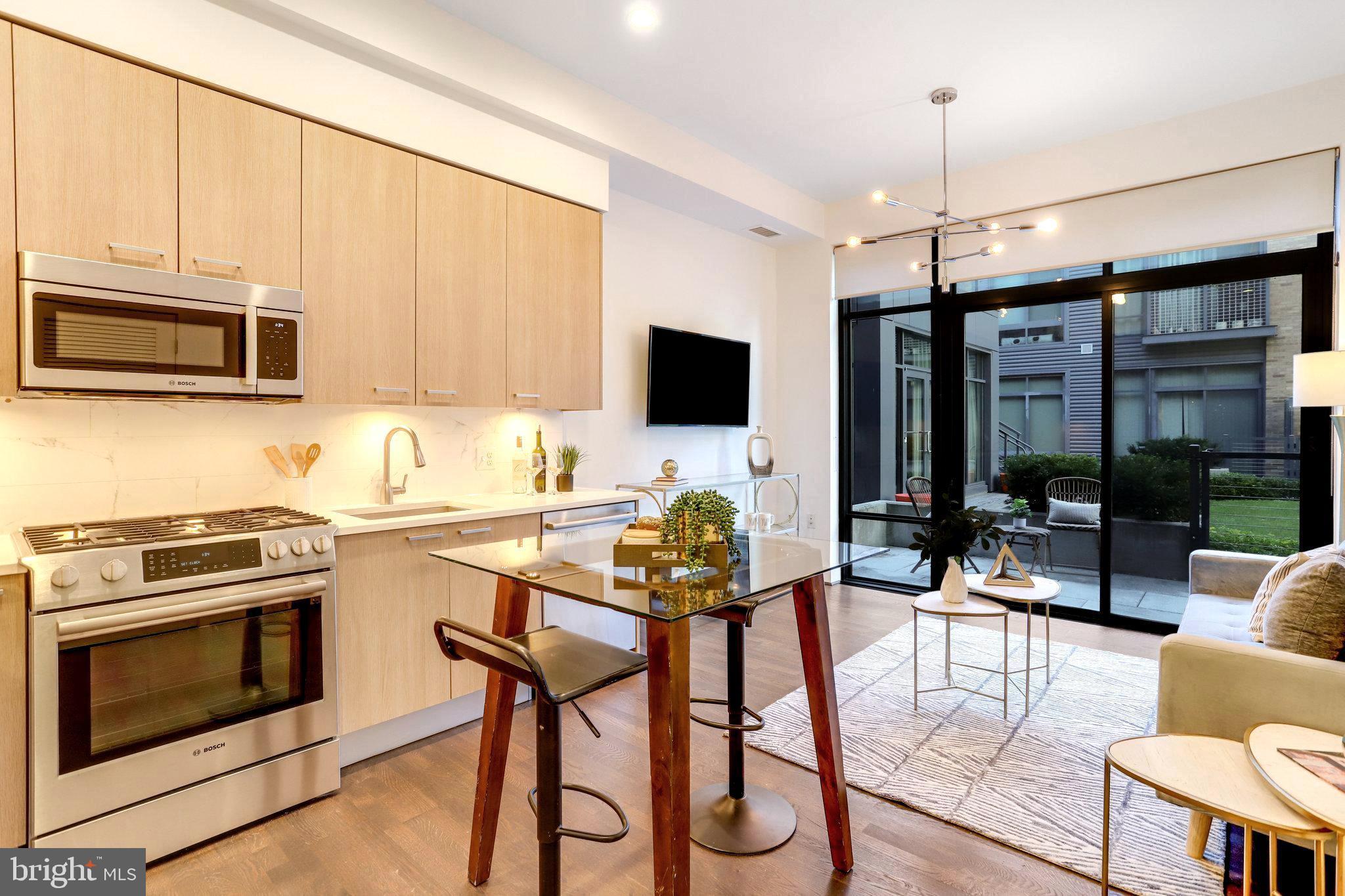 525 Water Street Southwest, Unit 223 Washington, DC 20024 - Photo 4 of 68 a view of kitchen with stainless steel appliances granite countertop a stove top oven a sink dishwasher a dining table and chairs with wooden floor