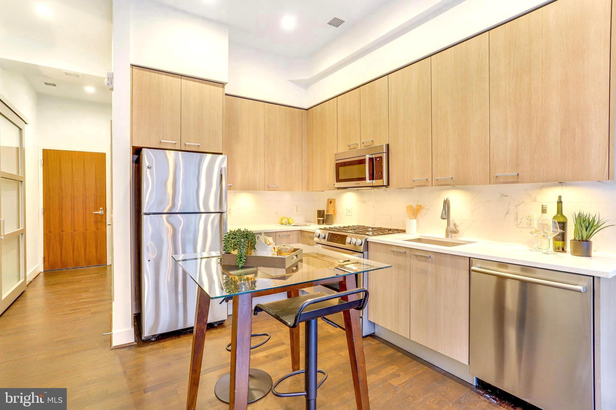 525 Water Street Southwest, Unit 223 Washington, DC 20024 - Photo 6 of 68 a kitchen with stainless steel appliances a stove a sink refrigerator and a microwave