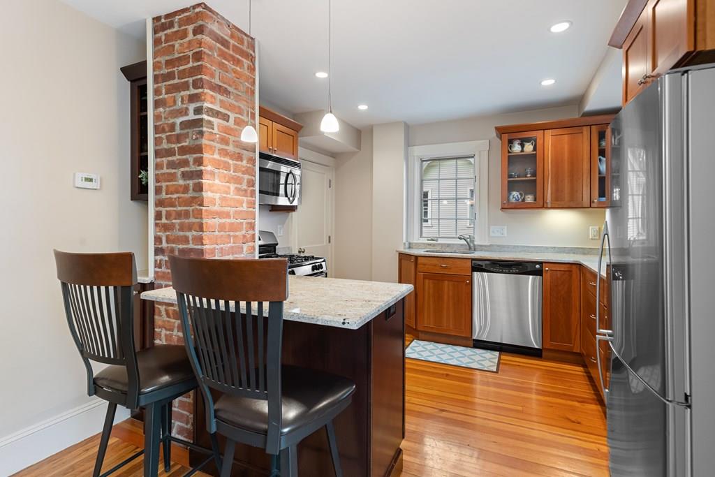 44 Sutherland Road Arlington, MA 02476 - Photo 10 of 21 a open kitchen with a table chairs and a refrigerator