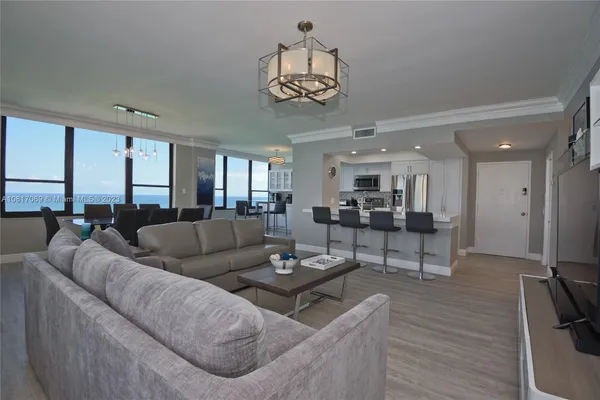 a living room with furniture kitchen and a chandelier