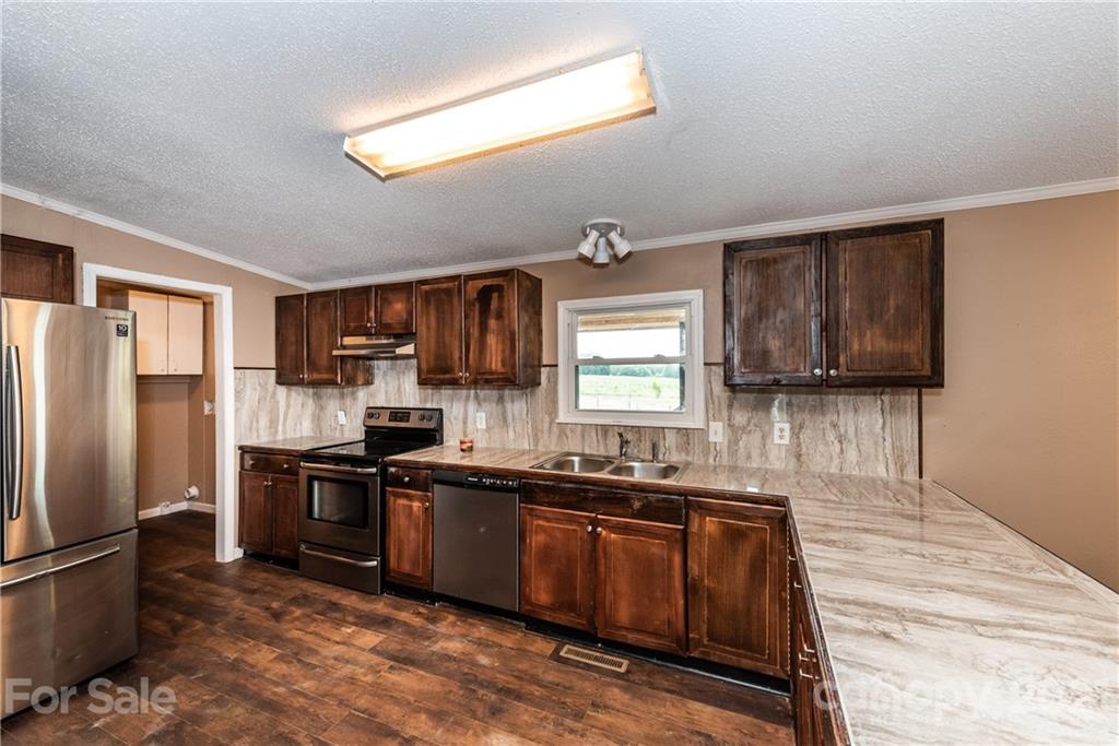 4638 Barrier Road Concord, NC 28025 - Photo 12 of 43 a kitchen with stainless steel appliances granite countertop a sink stove and refrigerator