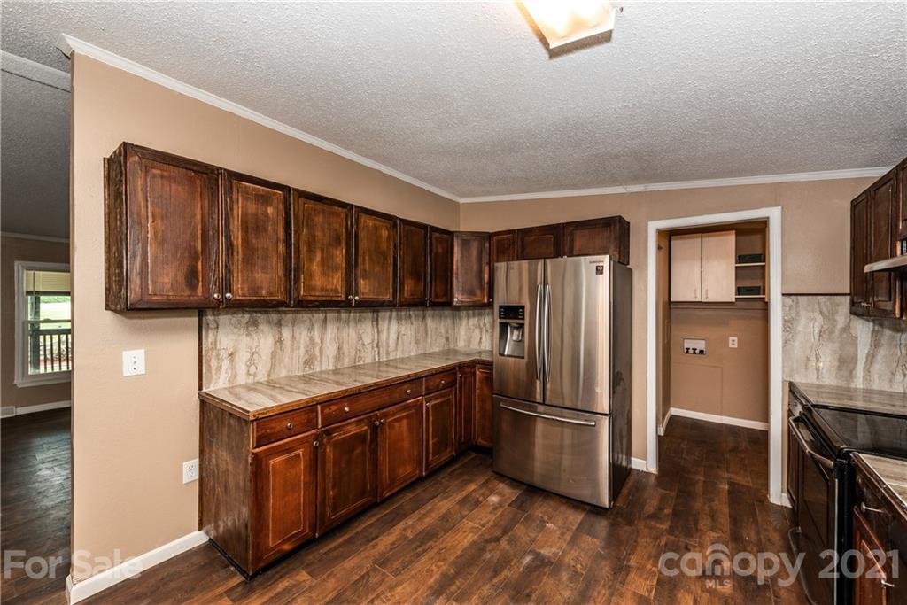 4638 Barrier Road Concord, NC 28025 - Photo 13 of 43 a kitchen with stainless steel appliances granite countertop a refrigerator a stove and a sink with wooden floor