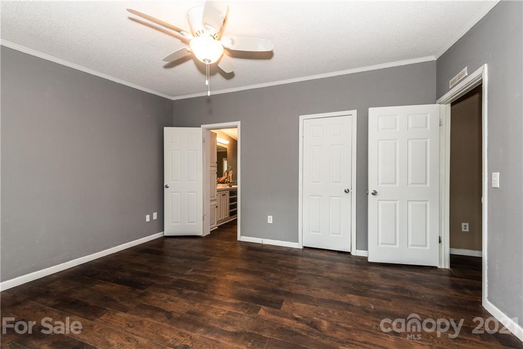 4638 Barrier Road Concord, NC 28025 - Photo 22 of 43 an empty room with wooden floor chandelier fan and windows