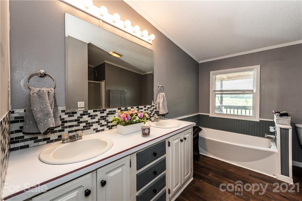4638 Barrier Road Concord, NC 28025 - Photo 23 of 43 a bathroom with a double vanity sink a mirror and bathtub