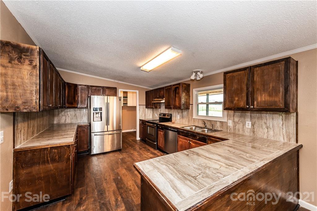 4638 Barrier Road Concord, NC 28025 - Photo 8 of 43 a kitchen with stainless steel appliances granite countertop a refrigerator stove top oven and sink