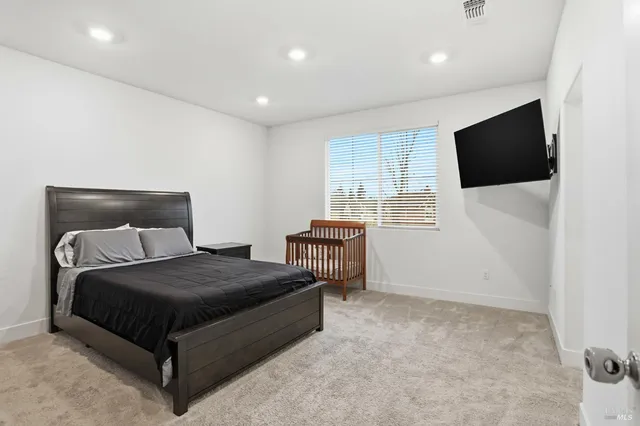 a bedroom with a bed and a flat screen tv