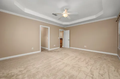 a view of an empty room with chandelier fan