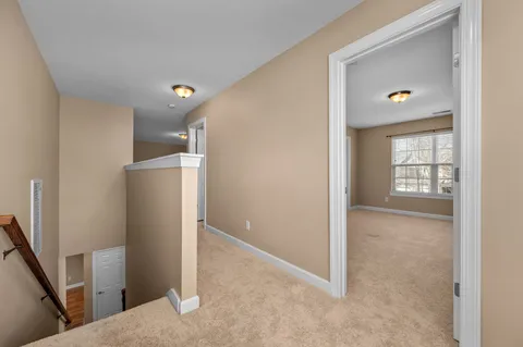 a view of a hallway with a livingroom and a window