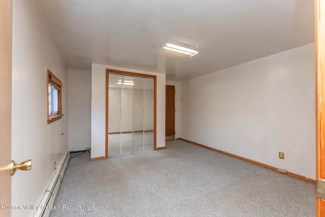 an empty room with a ceiling fan and window