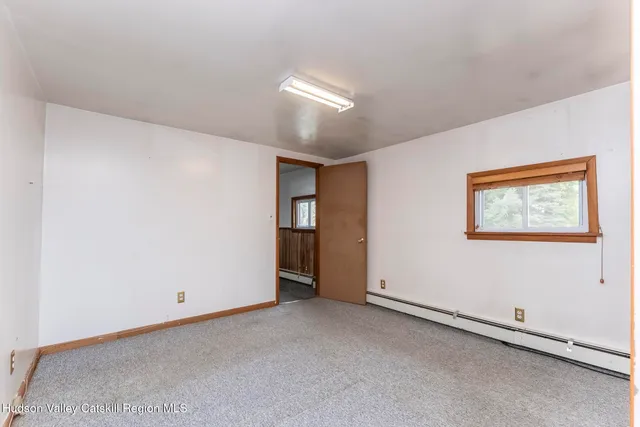 an empty room with windows and closet