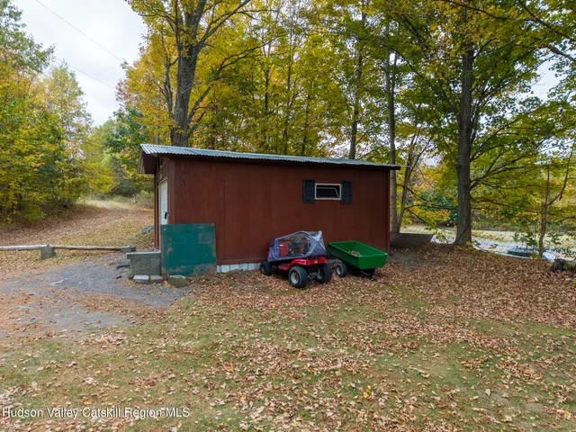 a view of a house with a big yard and large trees