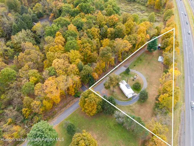 a view of swimming pool with seating area and trees in the background