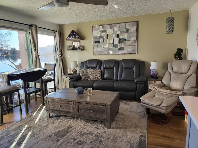 a living room with furniture wooden floor and a large window