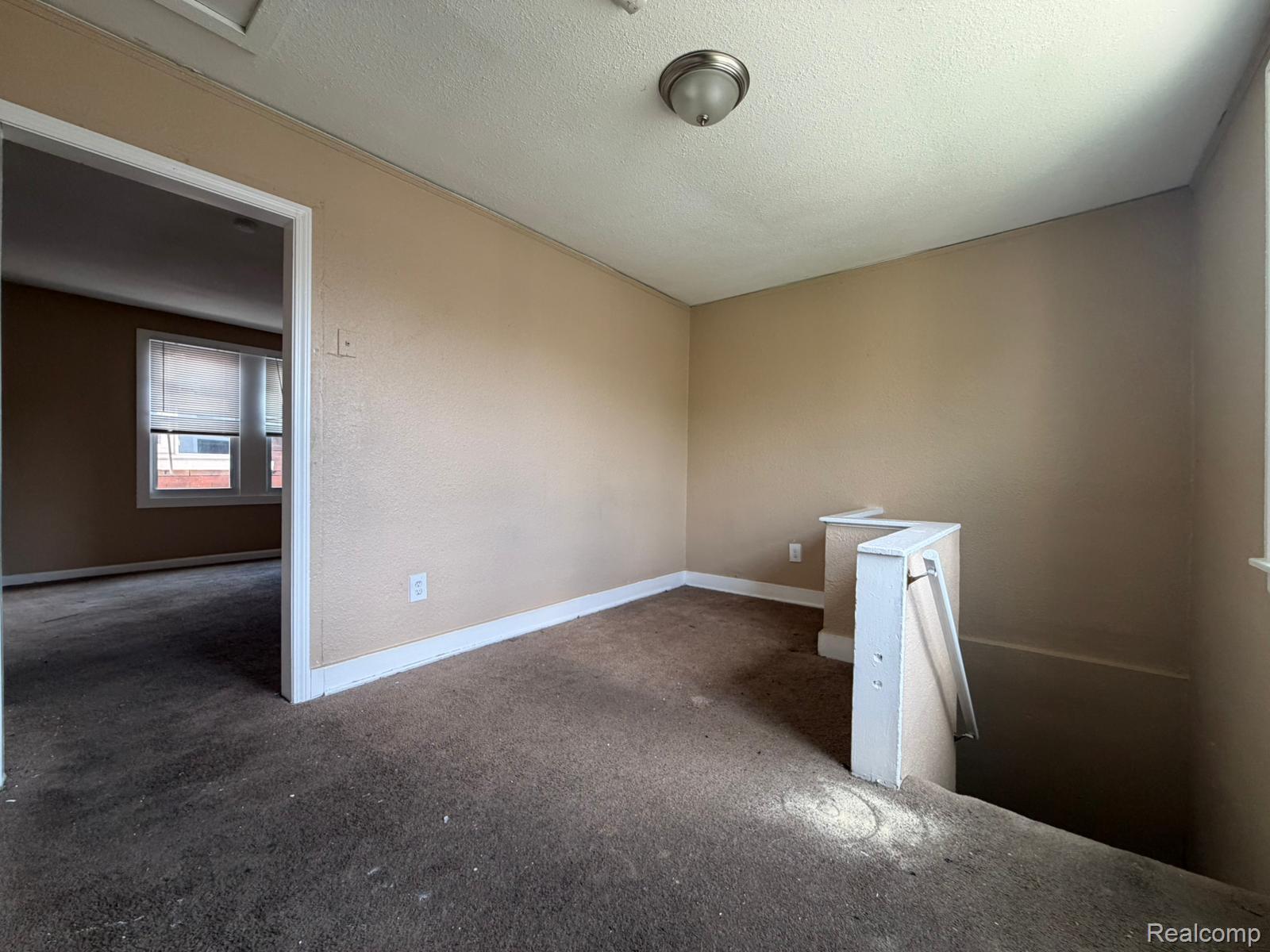 15935 Normandy Street Detroit, MI 48238 - Photo 22 of 28 Carpeted upper-level landing featuring a partial railing, neutral wall finishes, and white baseboards
