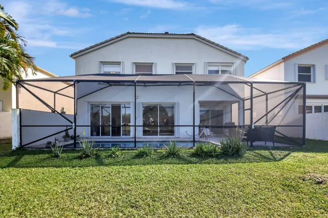 a view of a white house with a small yard and plants