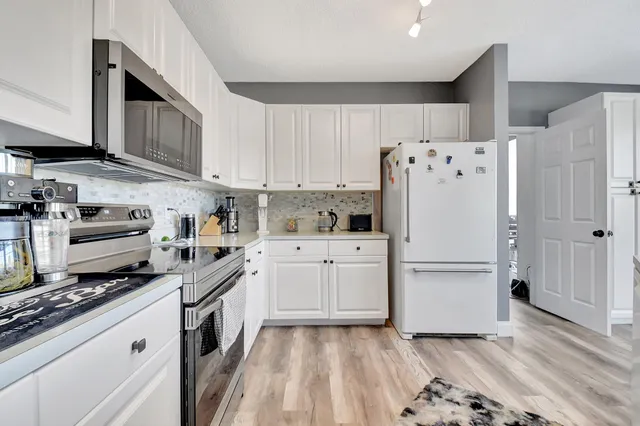 a kitchen with refrigerator a stove a sink and cabinets