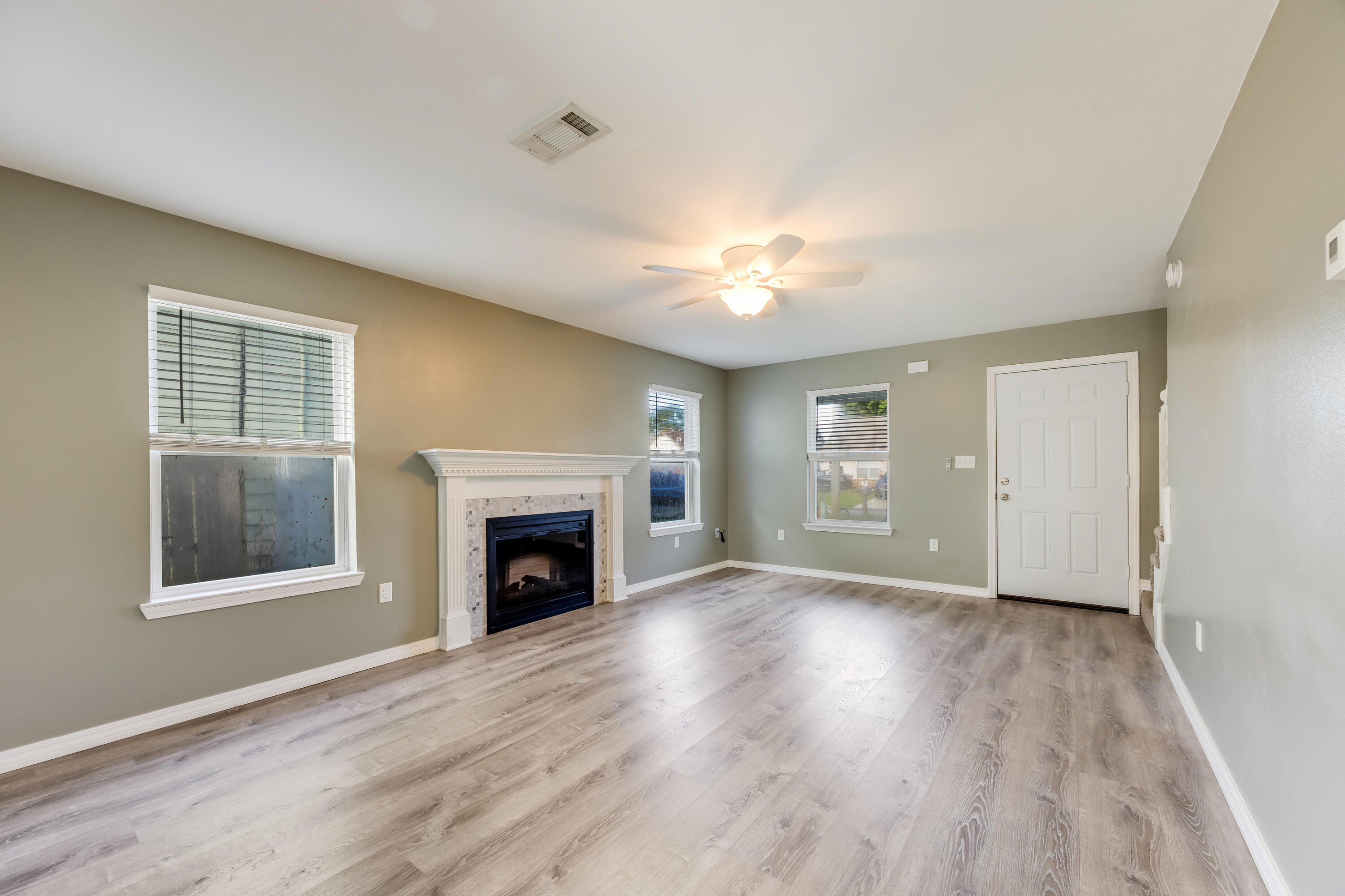 475 Sandy Ridge Circle Mary Esther, FL 32569 - Photo 5 of 26 an empty room with windows fireplace and wooden floor