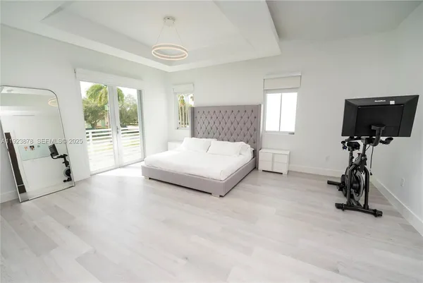 a bedroom with a bed and a flat tv screen on the dresser