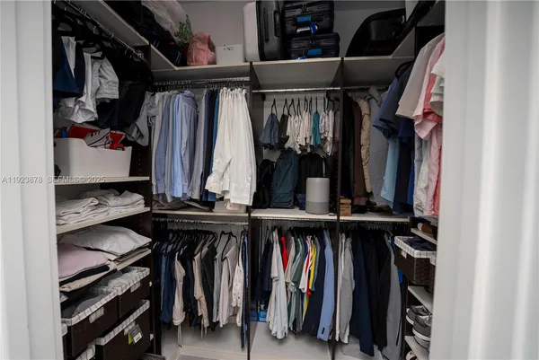 a view of walk in closet with clothes and shoes