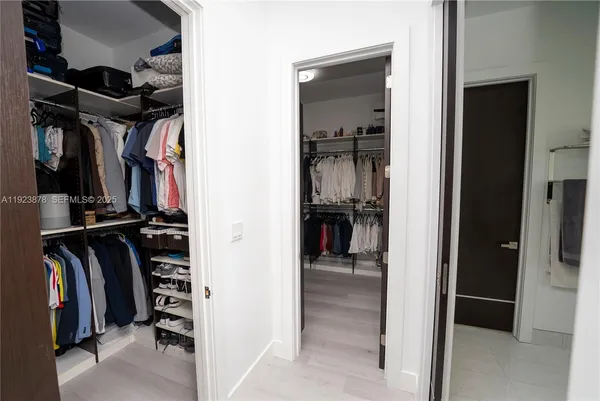 a view of walk in closet with clothes and shoes