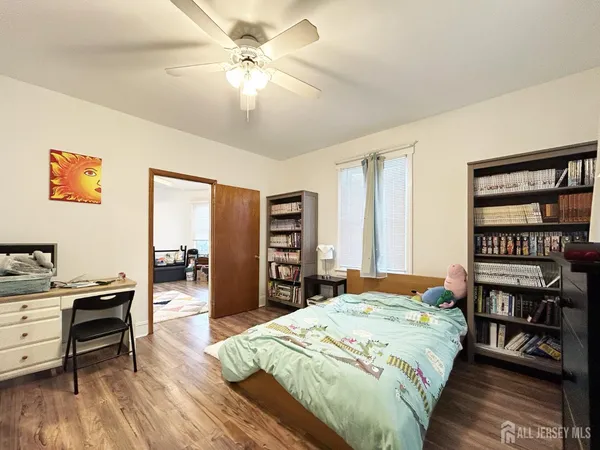 a bedroom with a bed a table and a bookshelf
