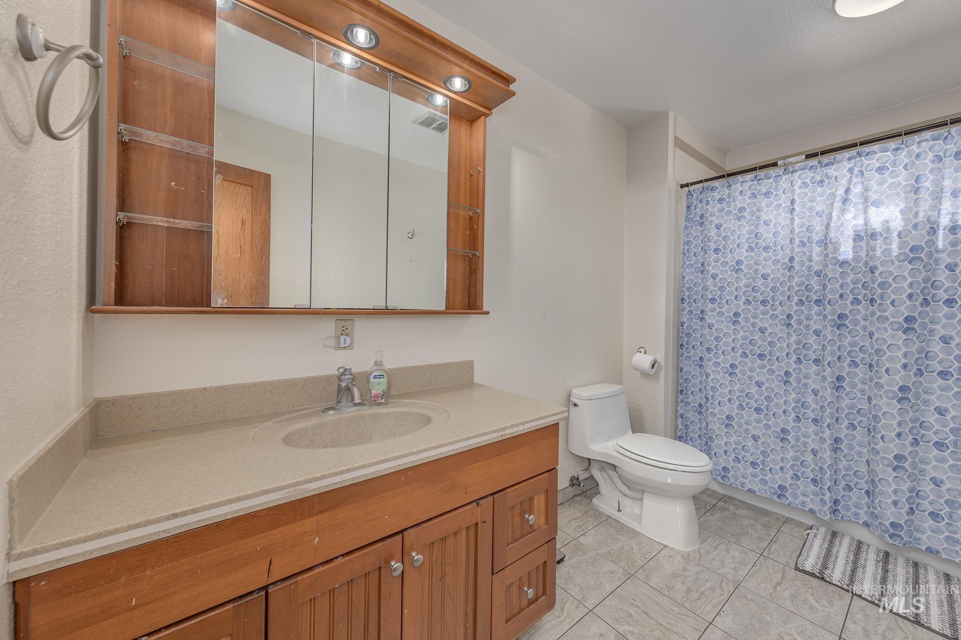 710 North 5th Street Nyssa, OR 97913 - Photo 17 of 36 Full bathroom with vanity, light tile patterned floors, and curtained shower
