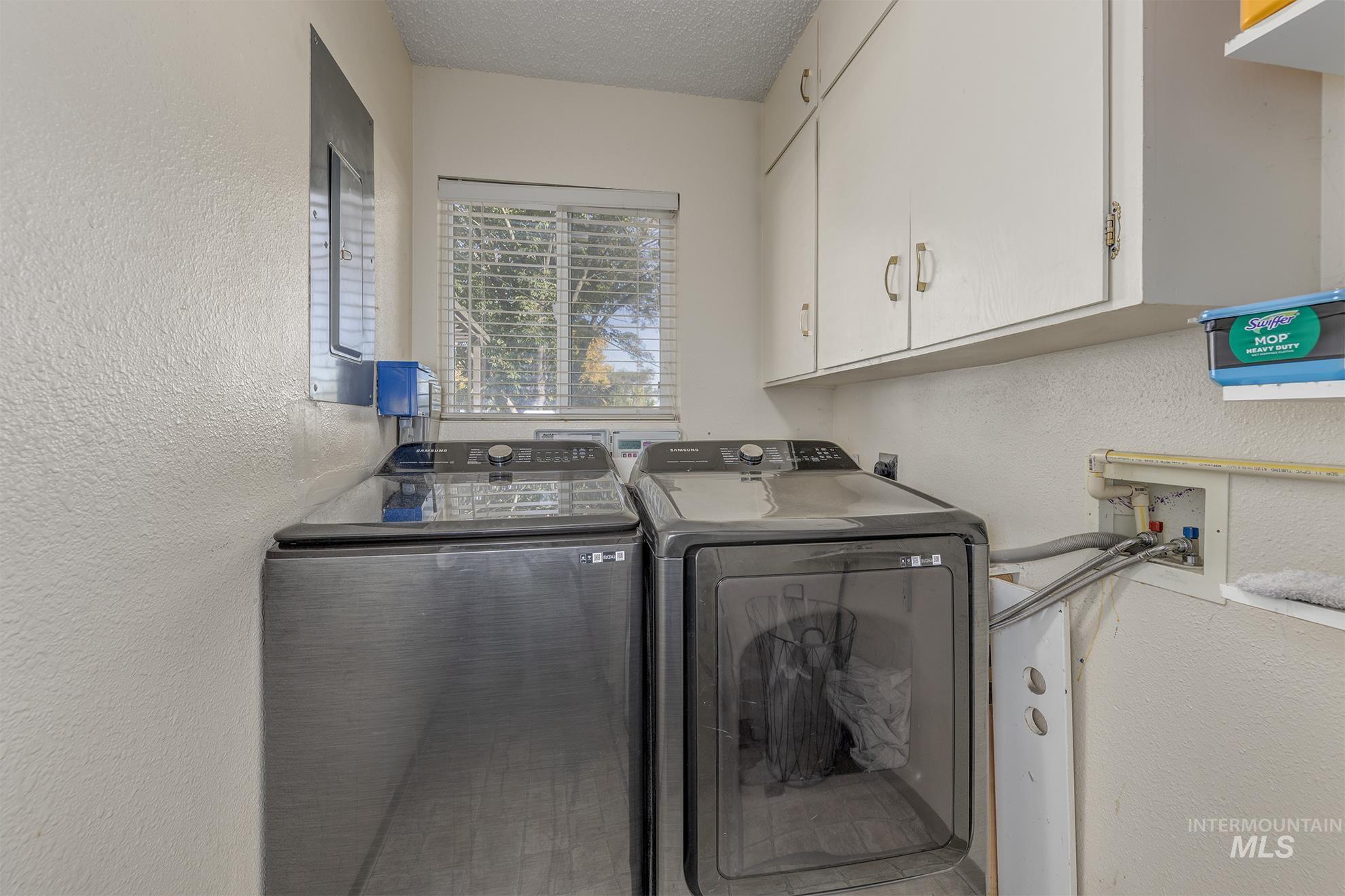 710 North 5th Street Nyssa, OR 97913 - Photo 18 of 36 Laundry room with a textured wall, a textured ceiling, separate washer and dryer, and cabinet space