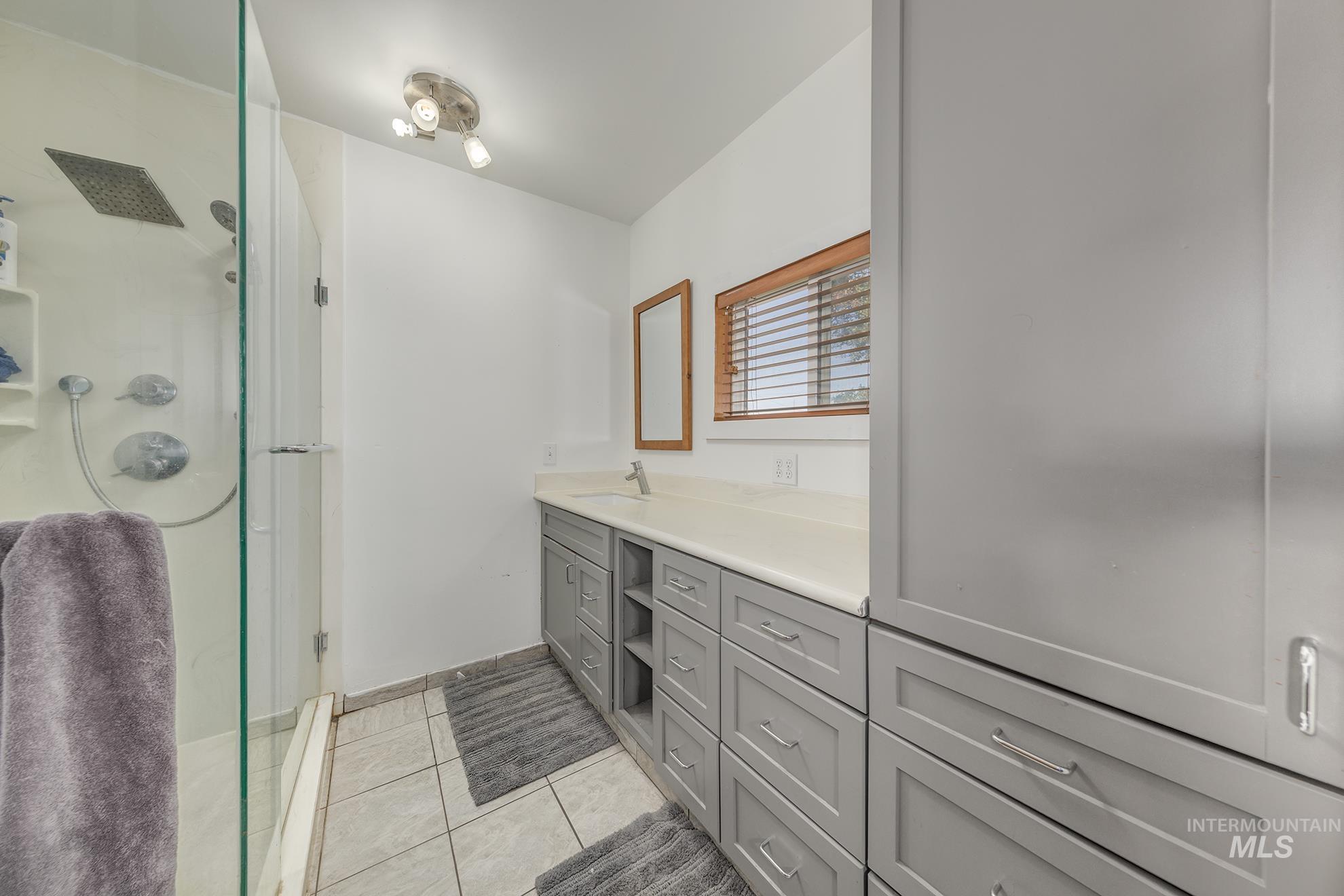 710 North 5th Street Nyssa, OR 97913 - Photo 23 of 36 Full bath with light tile patterned floors, a stall shower, and vanity, heated floors