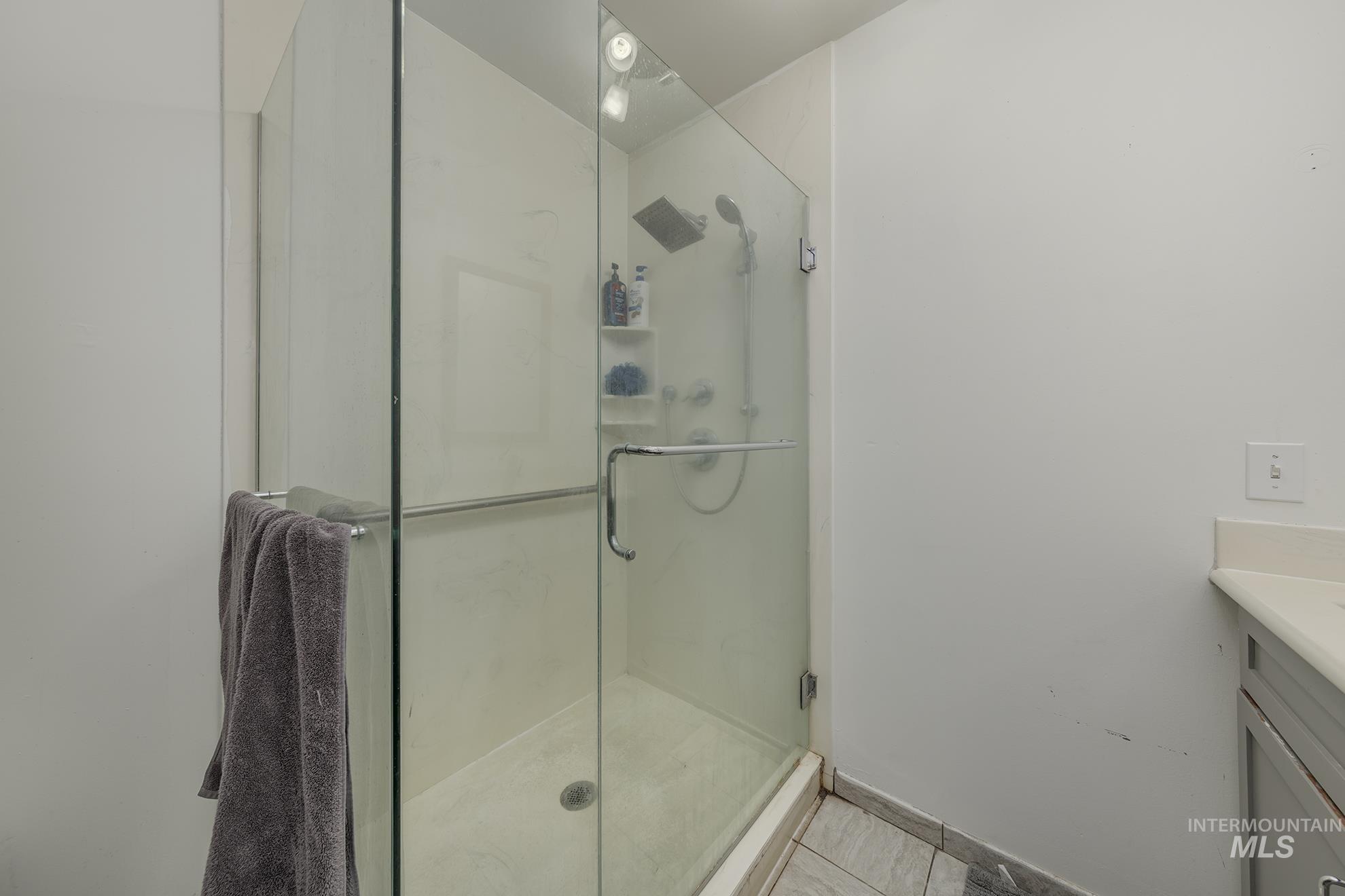710 North 5th Street Nyssa, OR 97913 - Photo 24 of 36 Full bathroom with vanity, a shower stall, and light tile patterned flooring