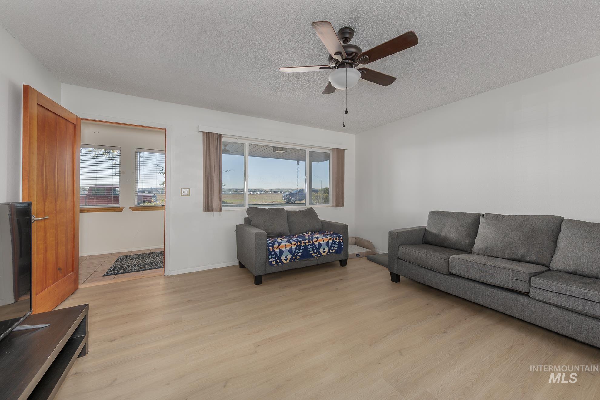 710 North 5th Street Nyssa, OR 97913 - Photo 8 of 36 Living area with light wood-style flooring, a textured ceiling, and ceiling fan