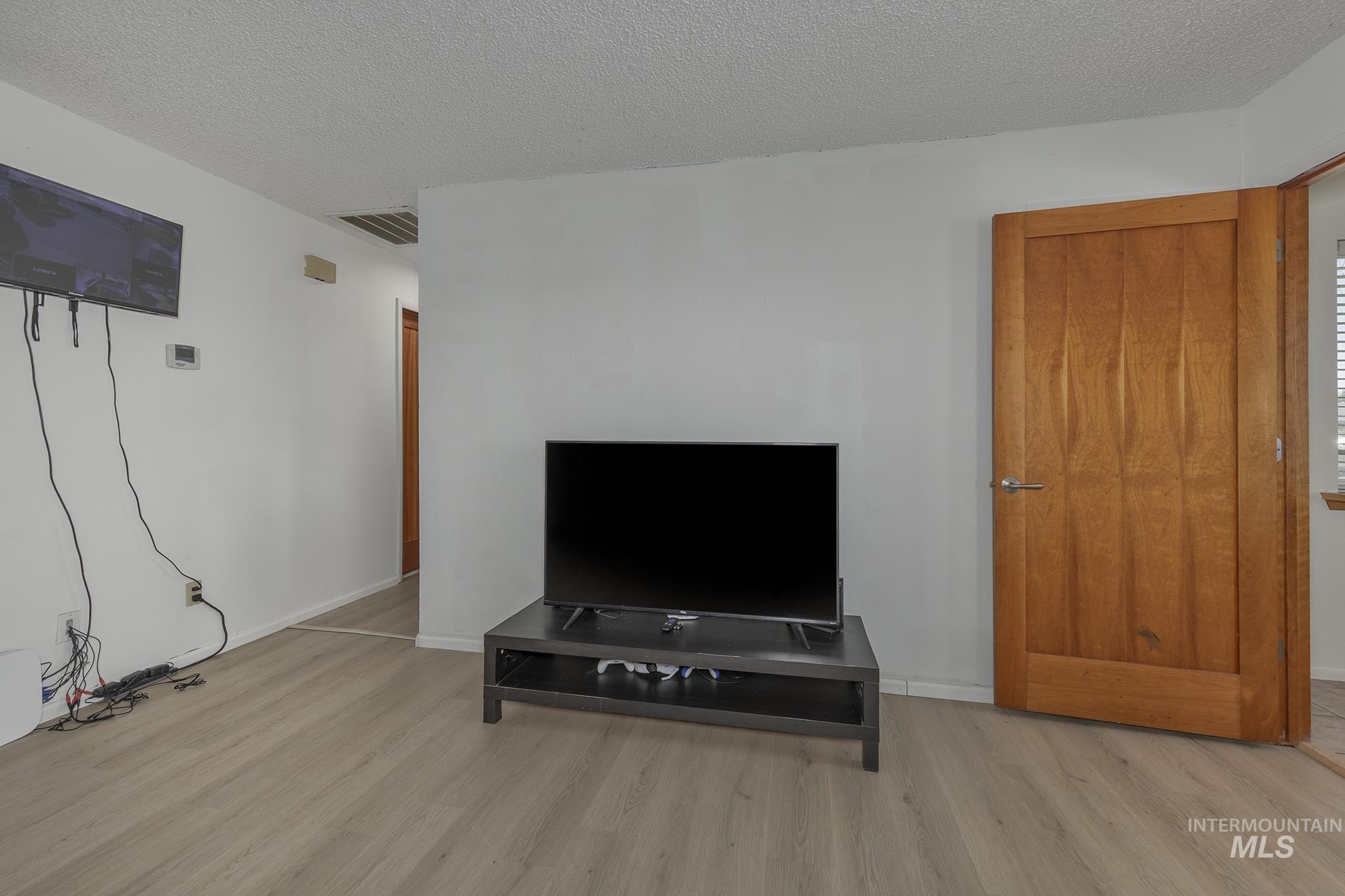 710 North 5th Street Nyssa, OR 97913 - Photo 9 of 36 Living room with wood finished floors and a textured ceiling