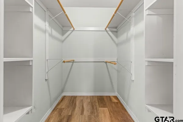 a view of walk in closet with wooden floor