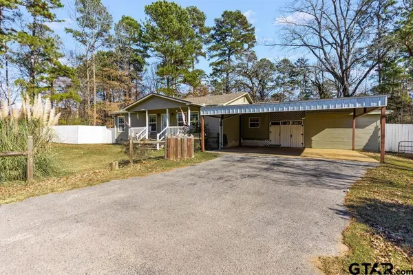 a row of trees with a house in the background
