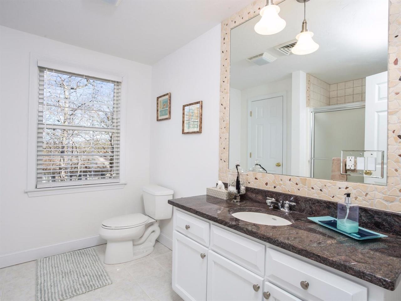 108 Fells Pond Road Mashpee, MA 02649 - Photo 25 of 35 a bathroom with double vanity a toilet a mirror and a window